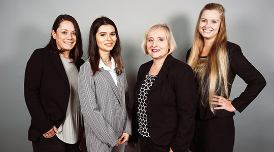 Das Team der Personalgewinnung besteht aus 4 Damen, die in Businesskleidung vor einem grauen Hintergrund stehen.